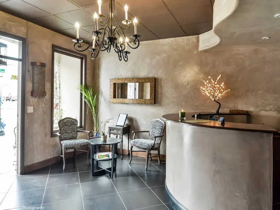 Reception: a chandelier over the curved plaster front desk, zebra-print chairs and a lit branch lamp