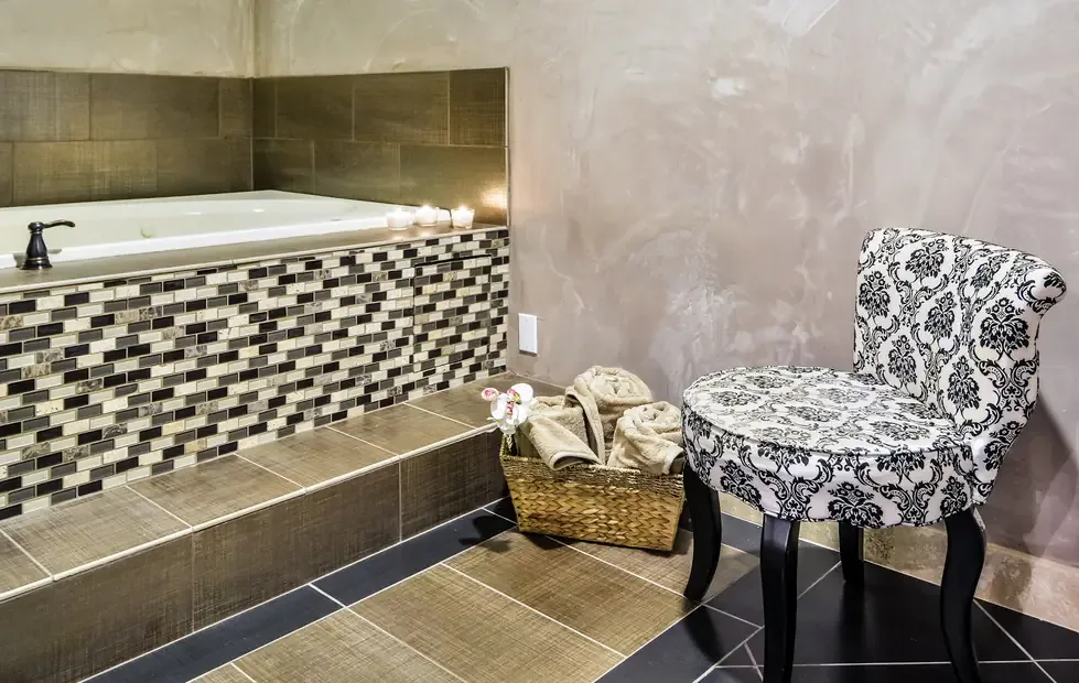 The bath tub jacuzzi at Heaven Scent: mosaic-tile surround, three tea lights and rolled towels in a basket