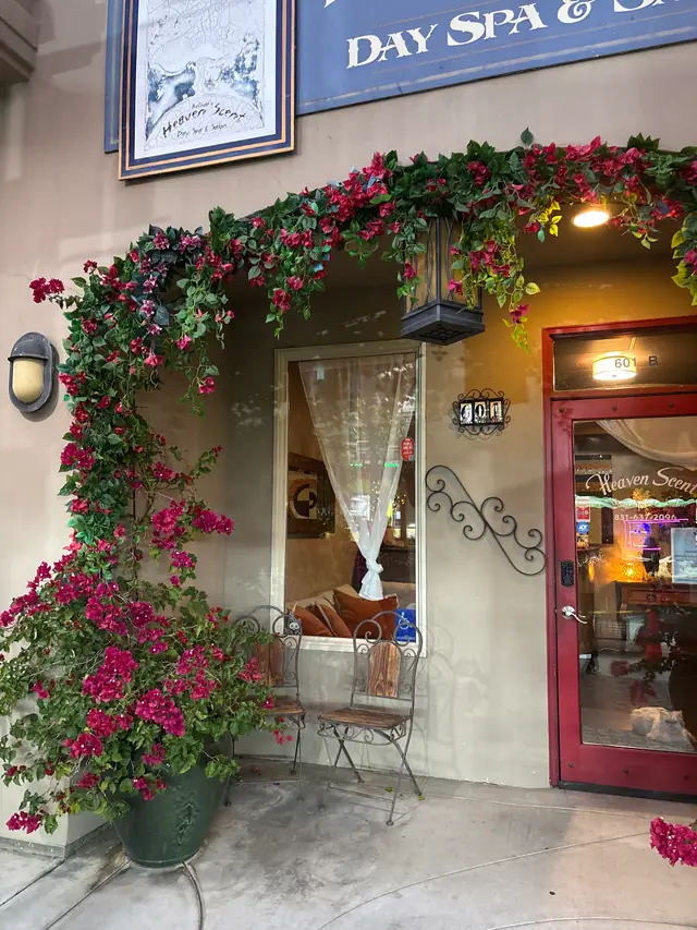 The red front door of Heaven Scent under a bougainvillea arch, the name and phone number painted on the glass